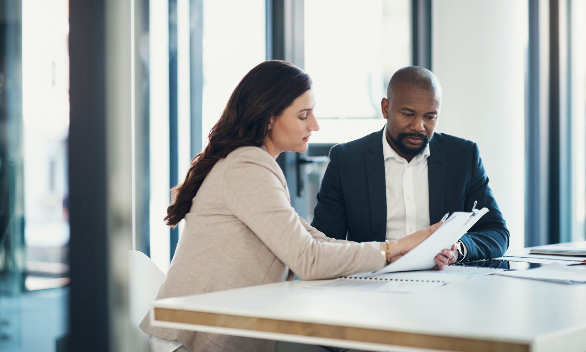 Business meeting, documents and people, clients or partner discussion of finance, loan and consultant advice. Taxes, review and woman with financial advisor or accountant, paperwork and information