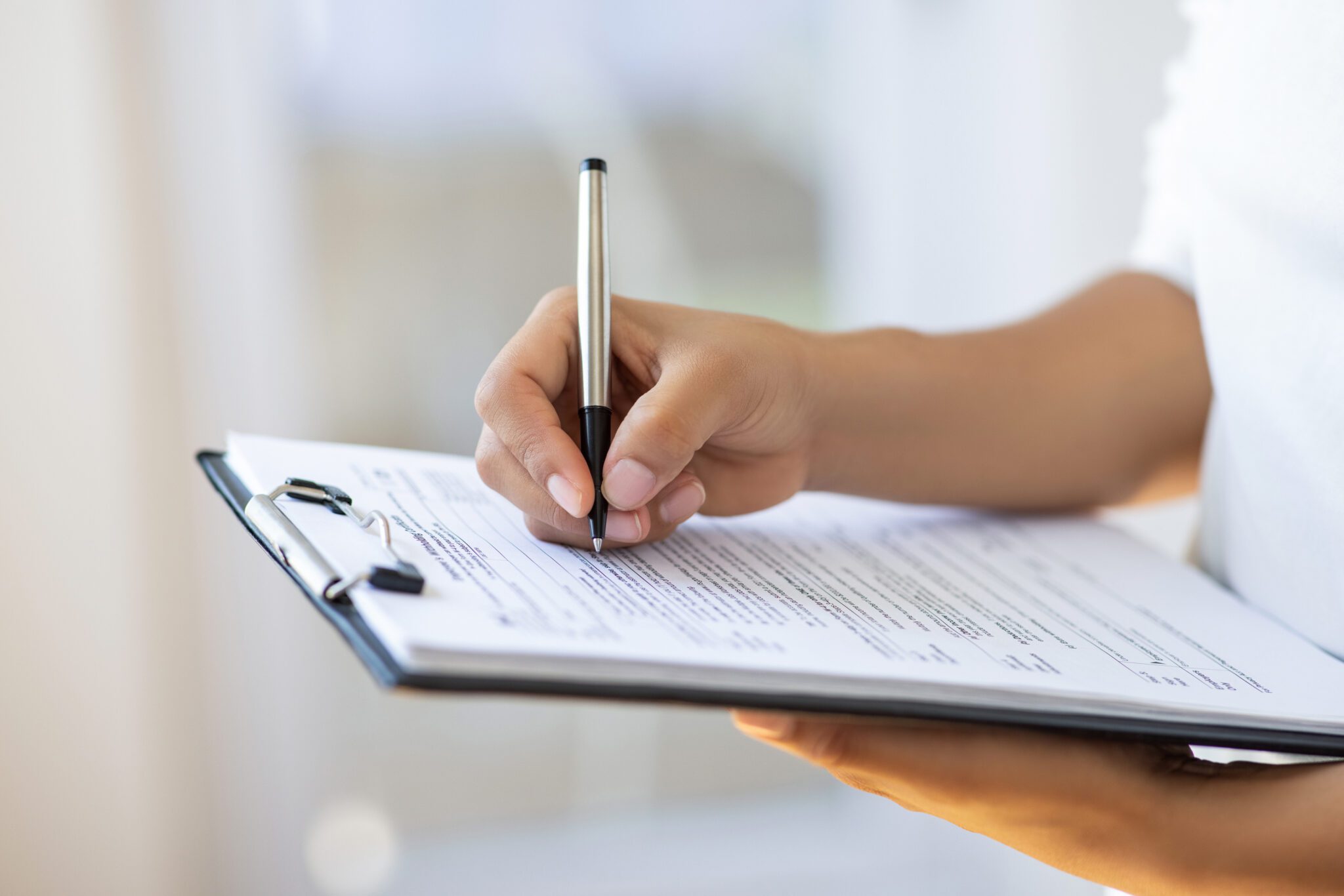 Holding clipboard and a pen in office
