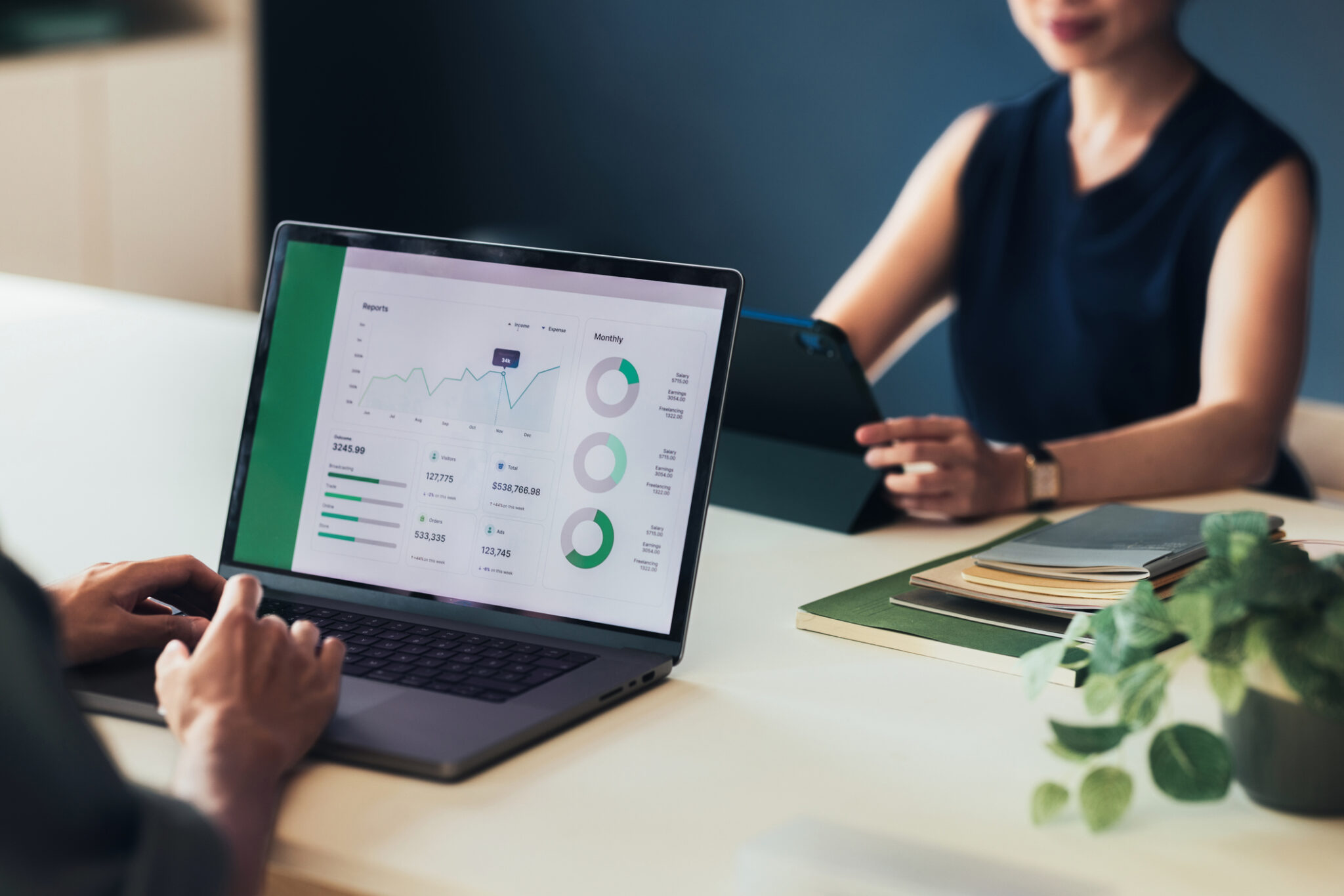 Professionals Analyzing Business Performance Data on Digital Devices in an Office Meeting