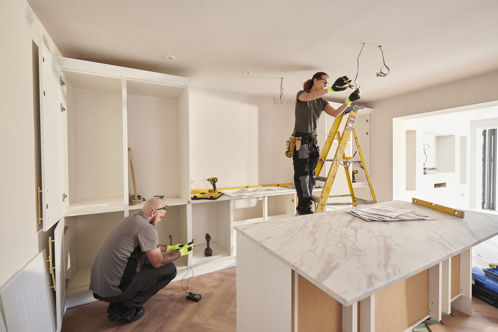 female electrician working in a kitchen remodelling