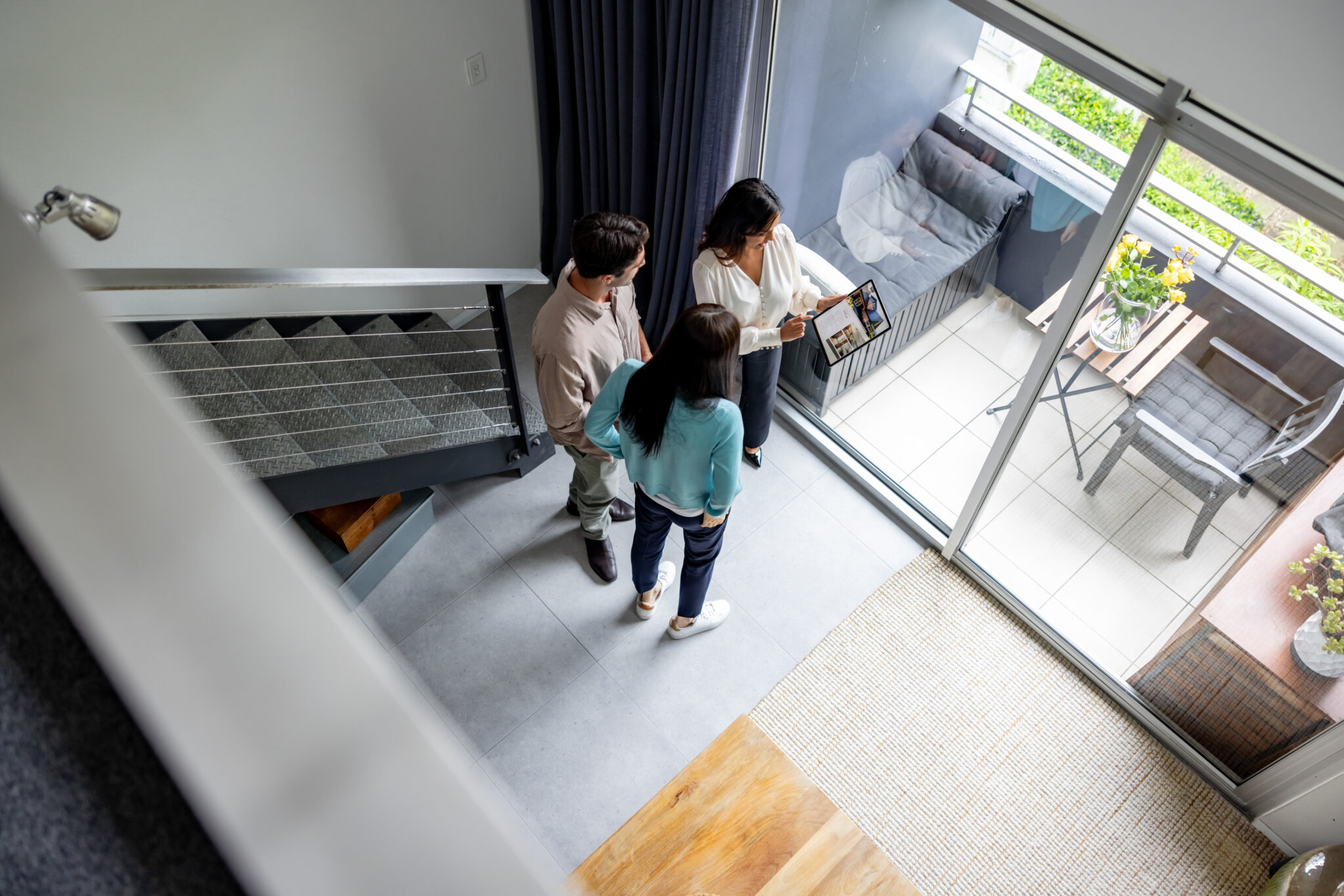 Real estate agent showing a house for sale to a couple while using a tablet