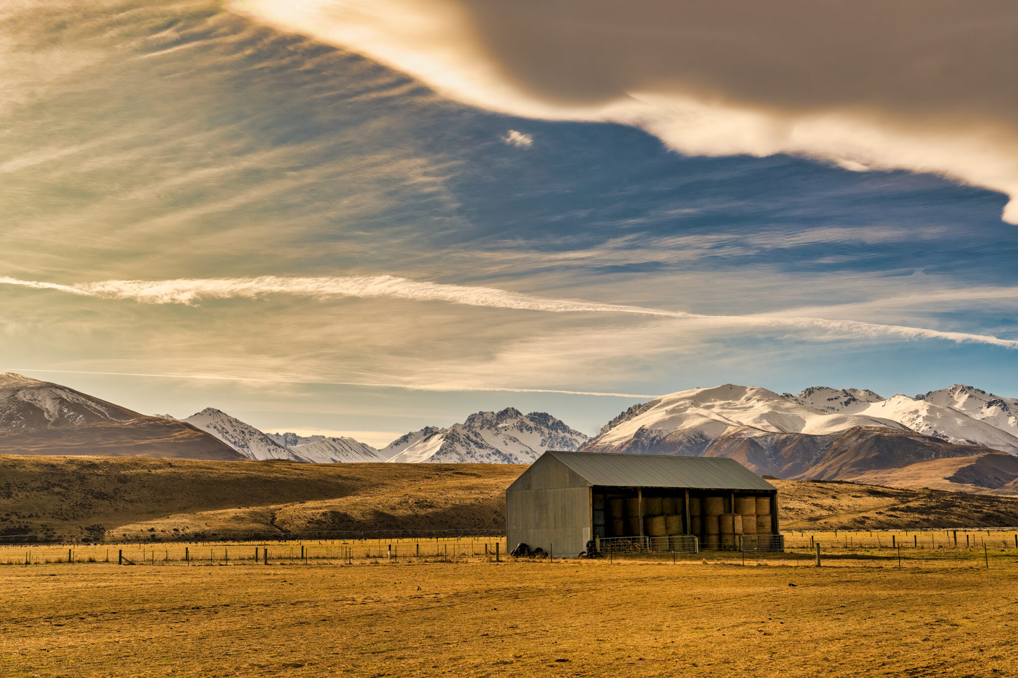 Agricultural land with a barn full of hay bales near Lake Tekapo