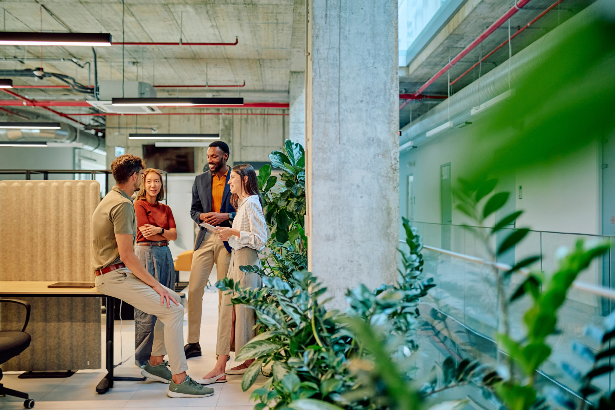 Businesspeople discussing in modern green office with plants