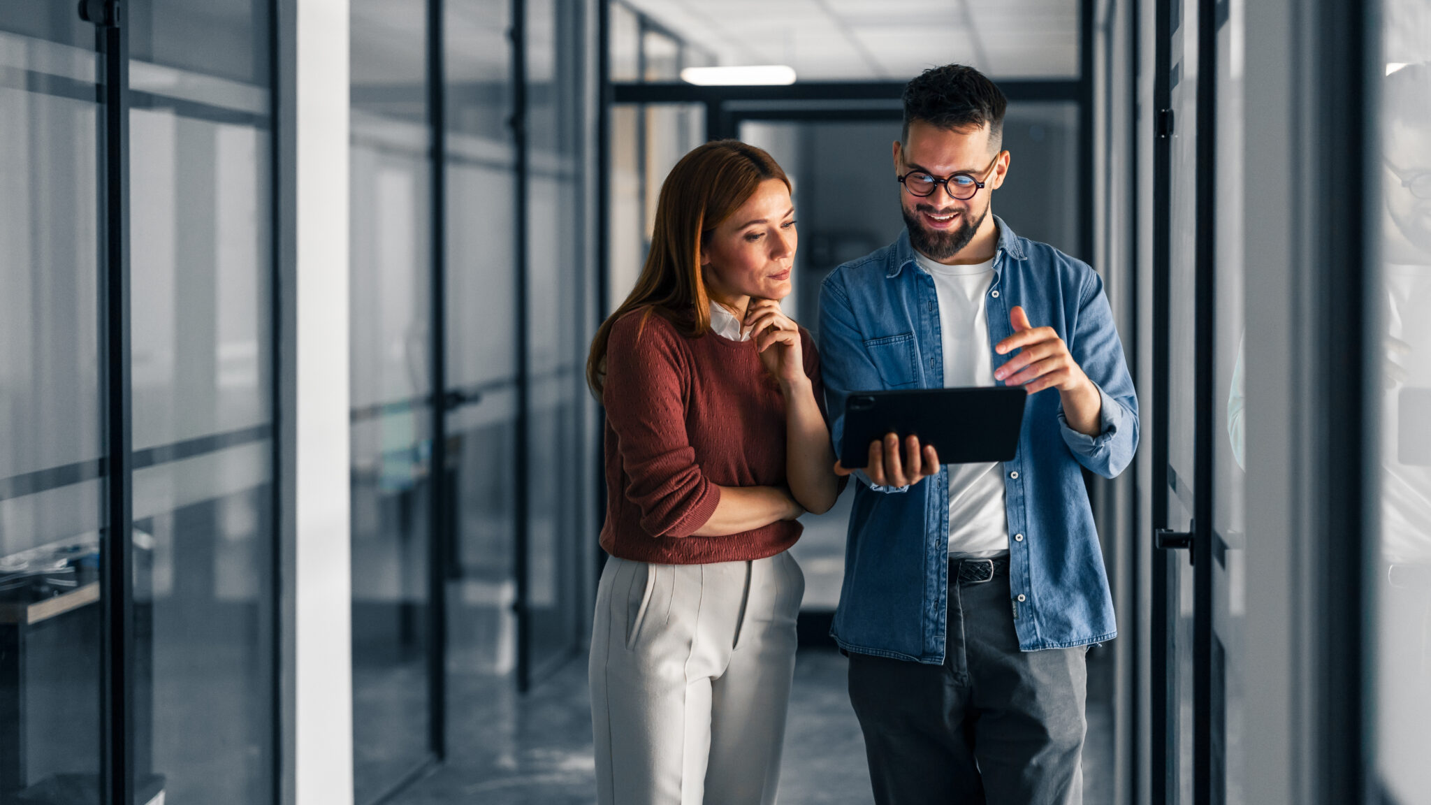 Two Professionals Discuss Work Using a Digital Tablet in an Office